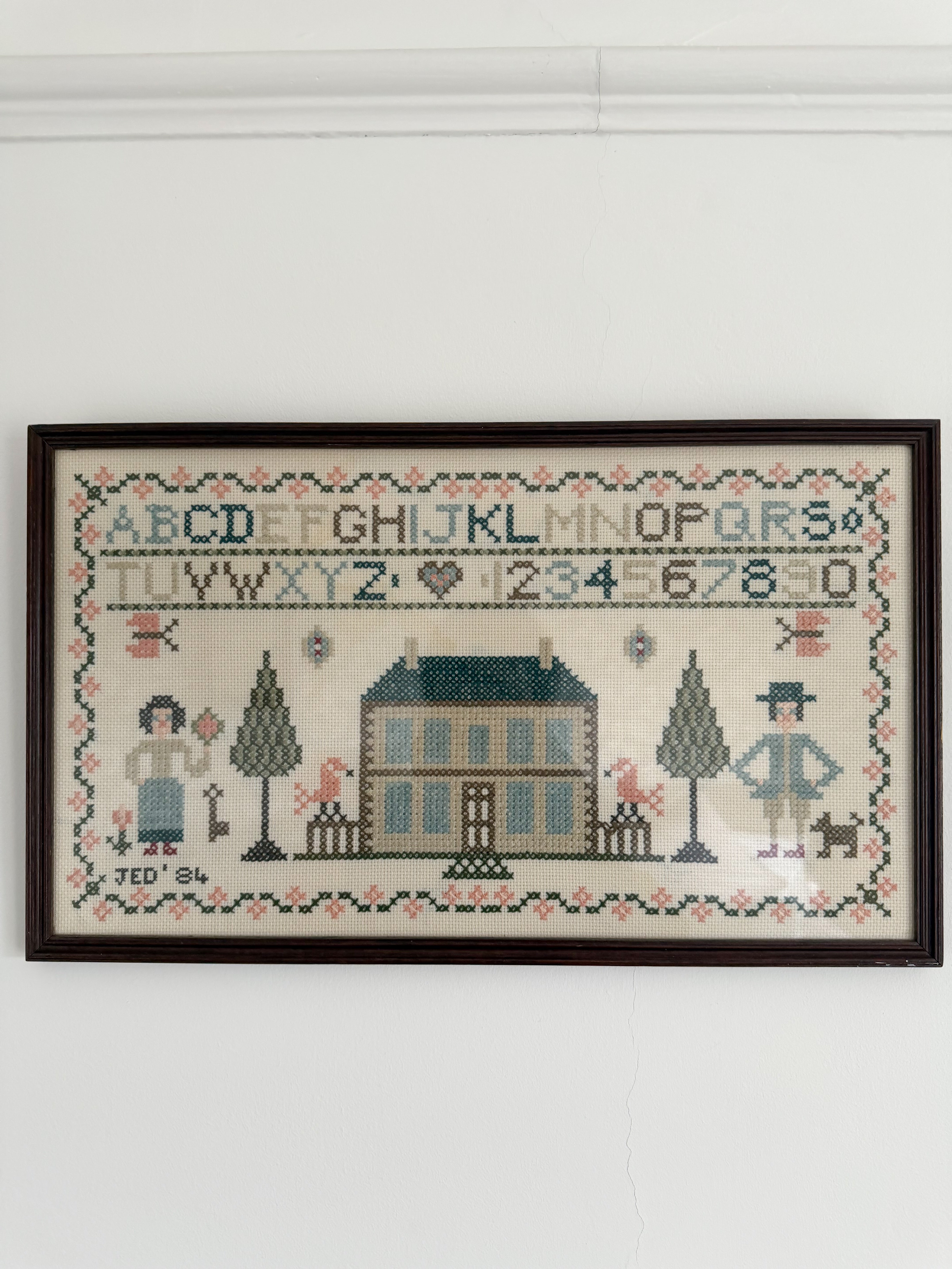 Vintage framed cross stitch sampler of a house, alphabet, numbers