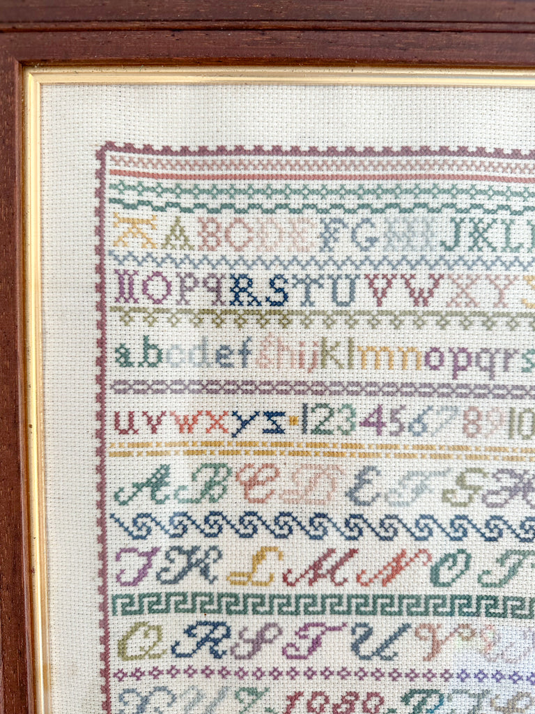 Vintage framed alphabet cross stitch embroidery sampler, in muted blue, pink, green and yellow - Moppet