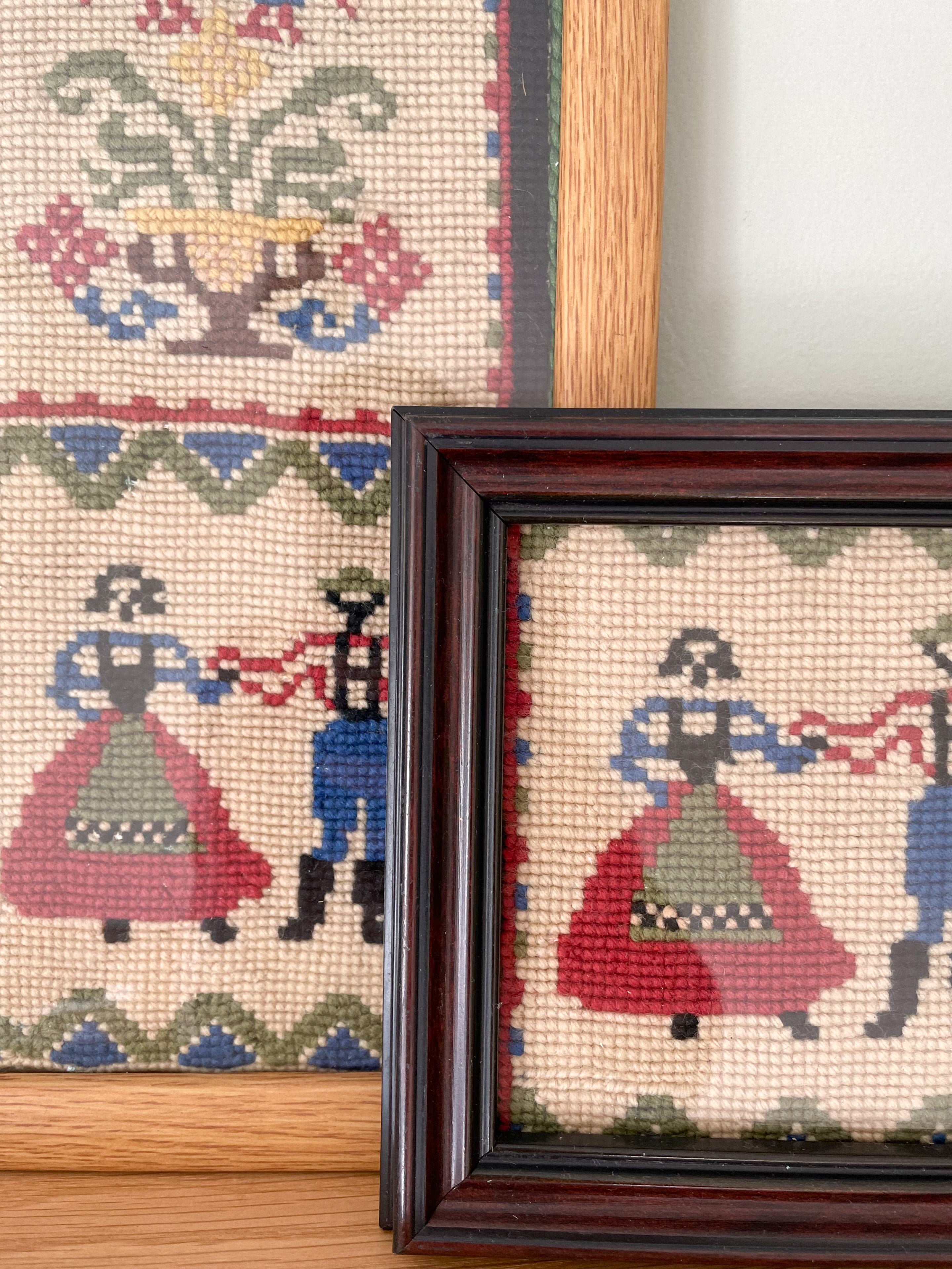 Pair of vintage framed embroideries featuring a European folk-art design of a dancing man and woman in traditional dress - Moppet