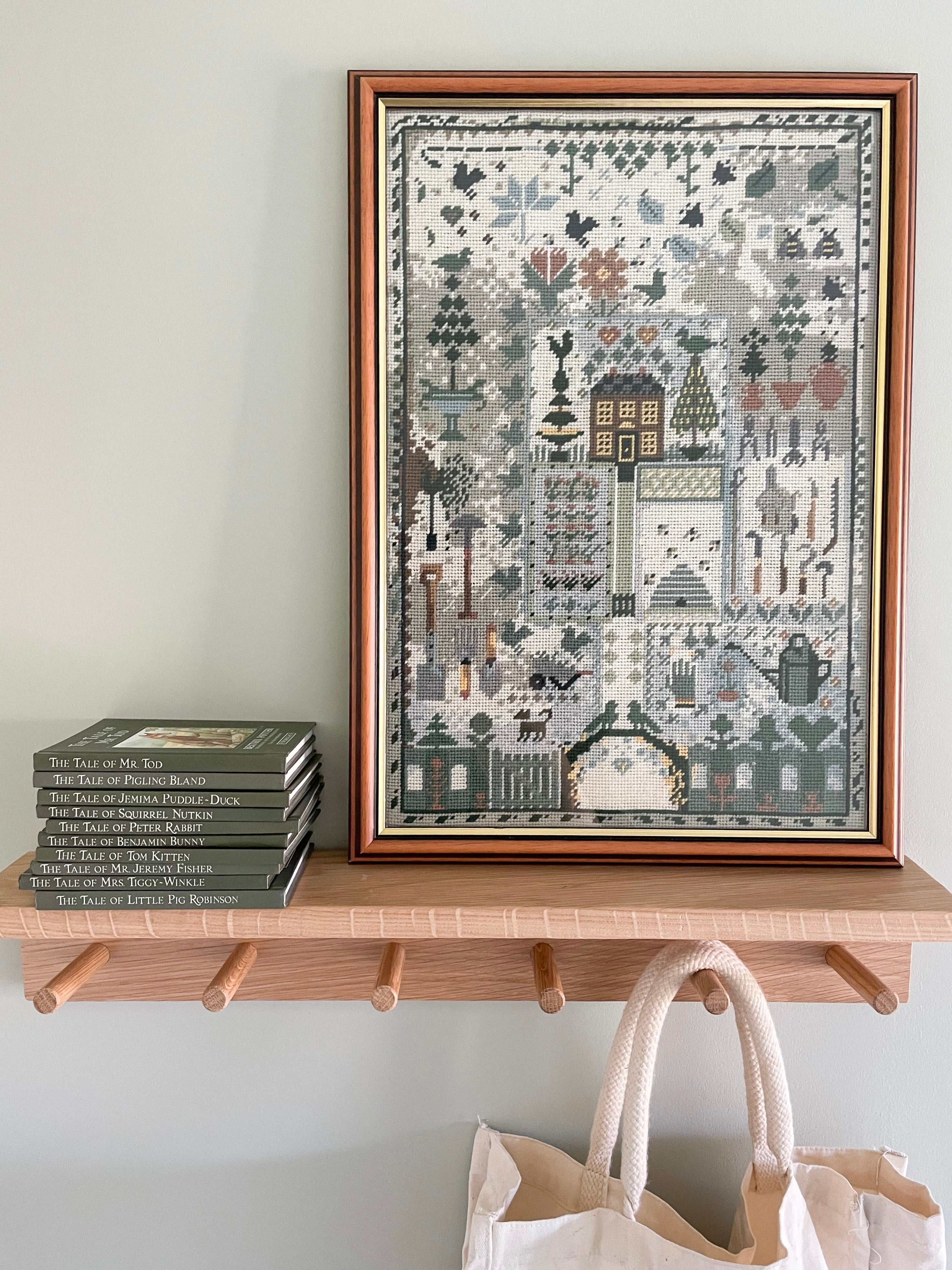 Vintage framed cross stitch of a garden in muted blues and greens - Moppet