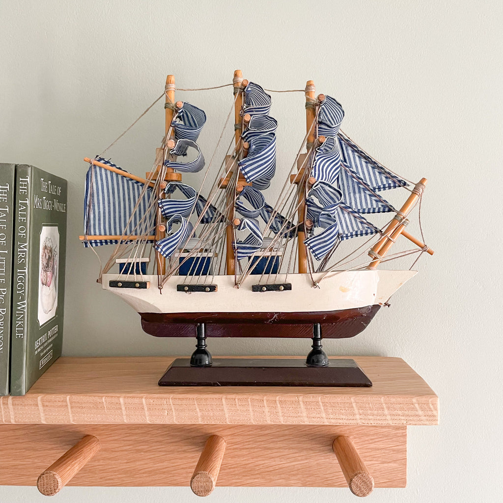 Vintage wooden model sailing ship with blue and white striped sails - Moppet