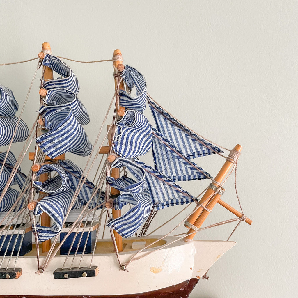 Vintage wooden model sailing ship with blue and white striped sails - Moppet