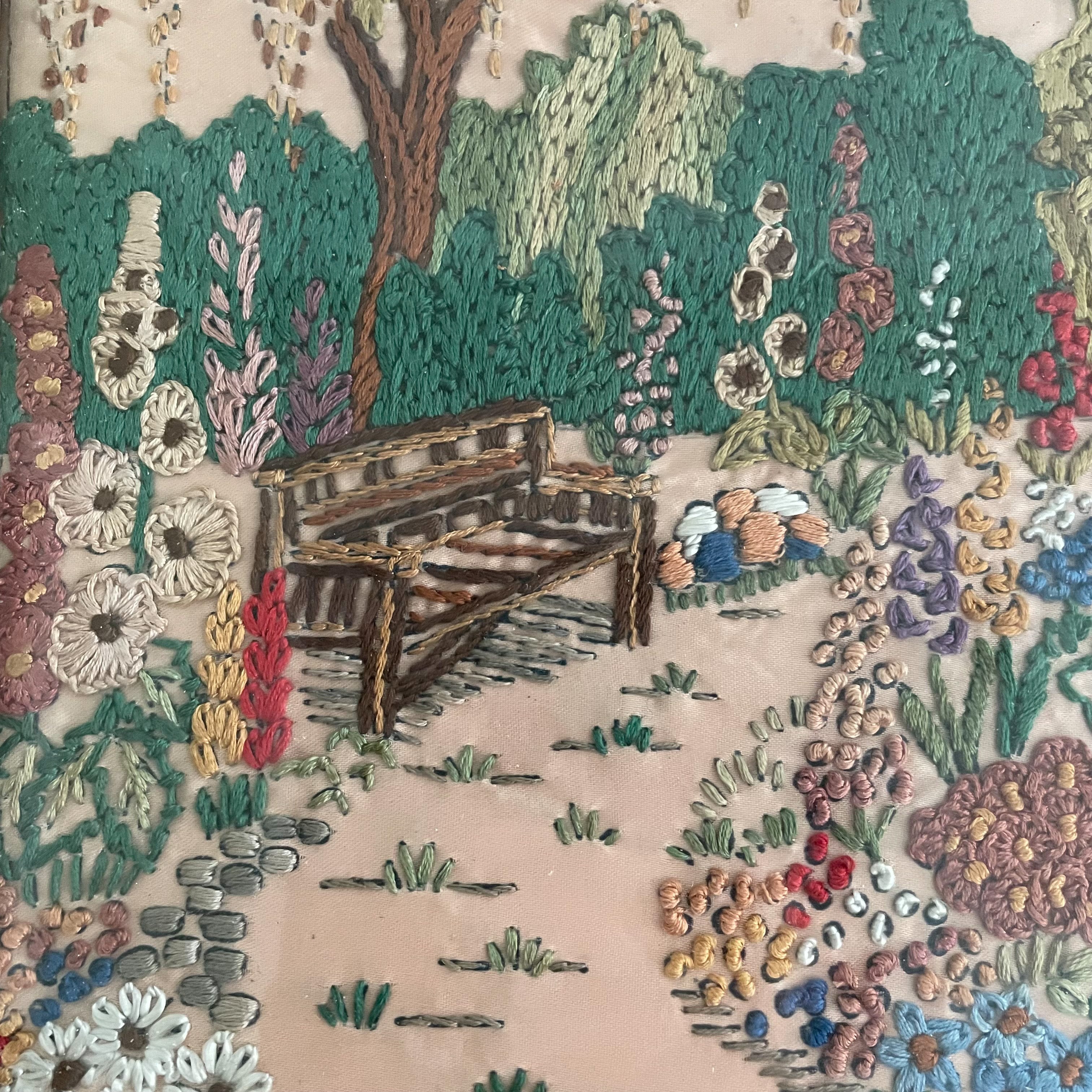 Vintage framed embroidery of a garden, house and bench, blush pink background - Moppet