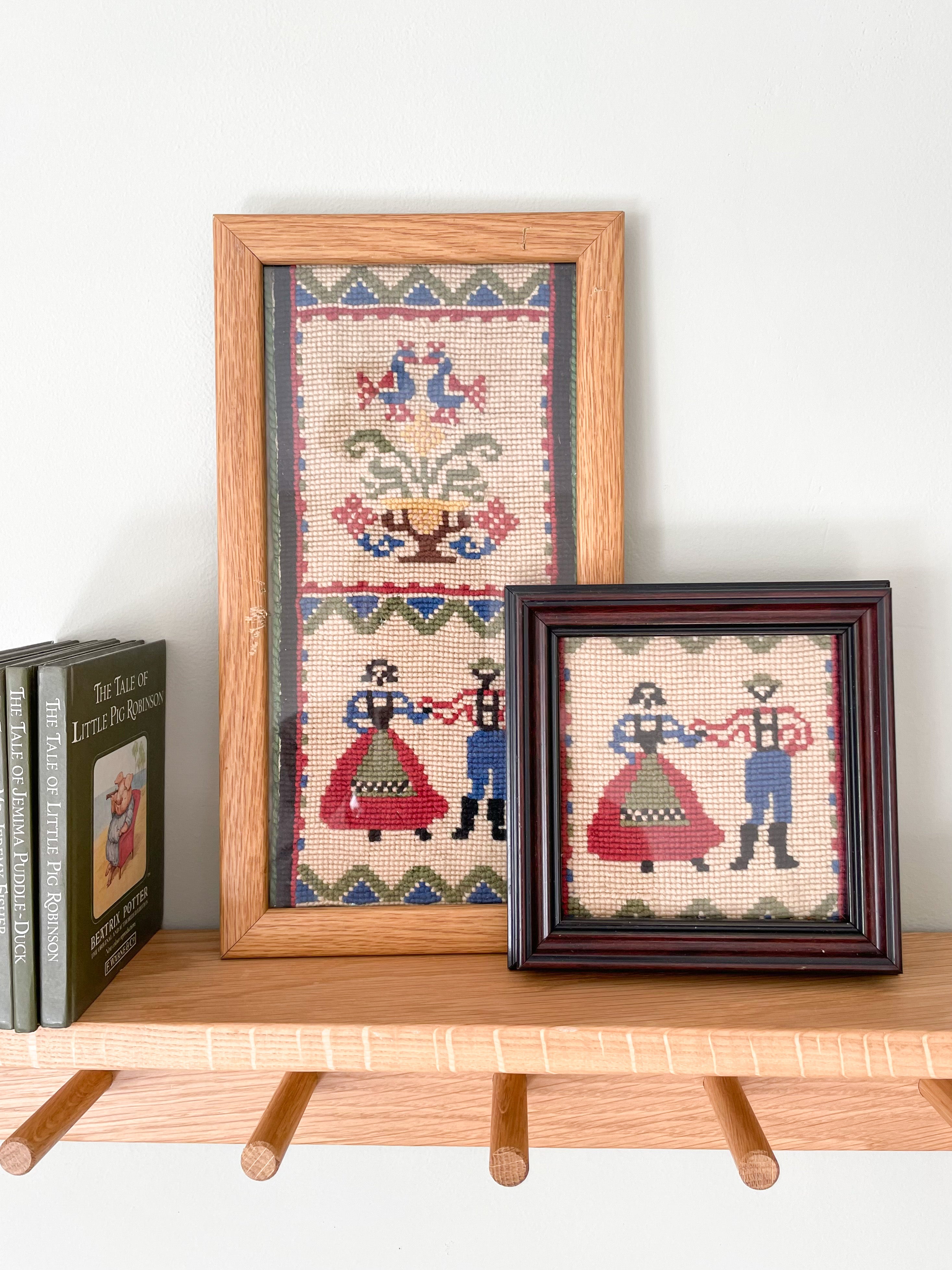 Pair of vintage framed embroideries featuring a European folk-art design of a dancing man and woman in traditional dress - Moppet