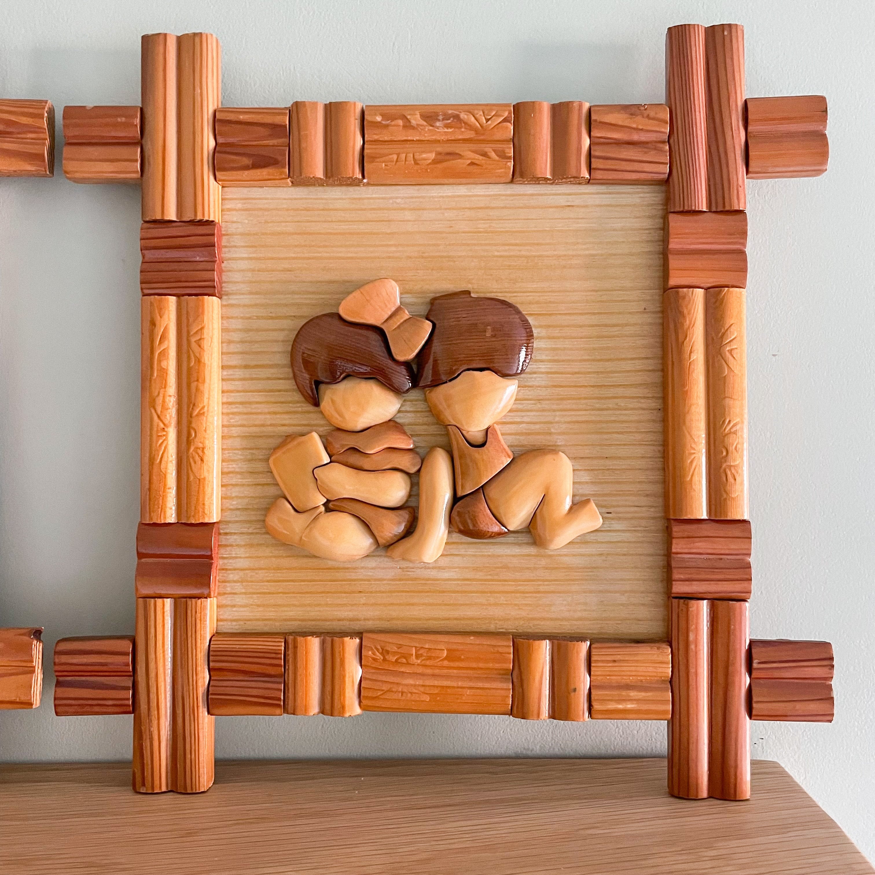Pair of wooden and bamboo framed wall plaques each featuring two small children, East Asian - Moppet