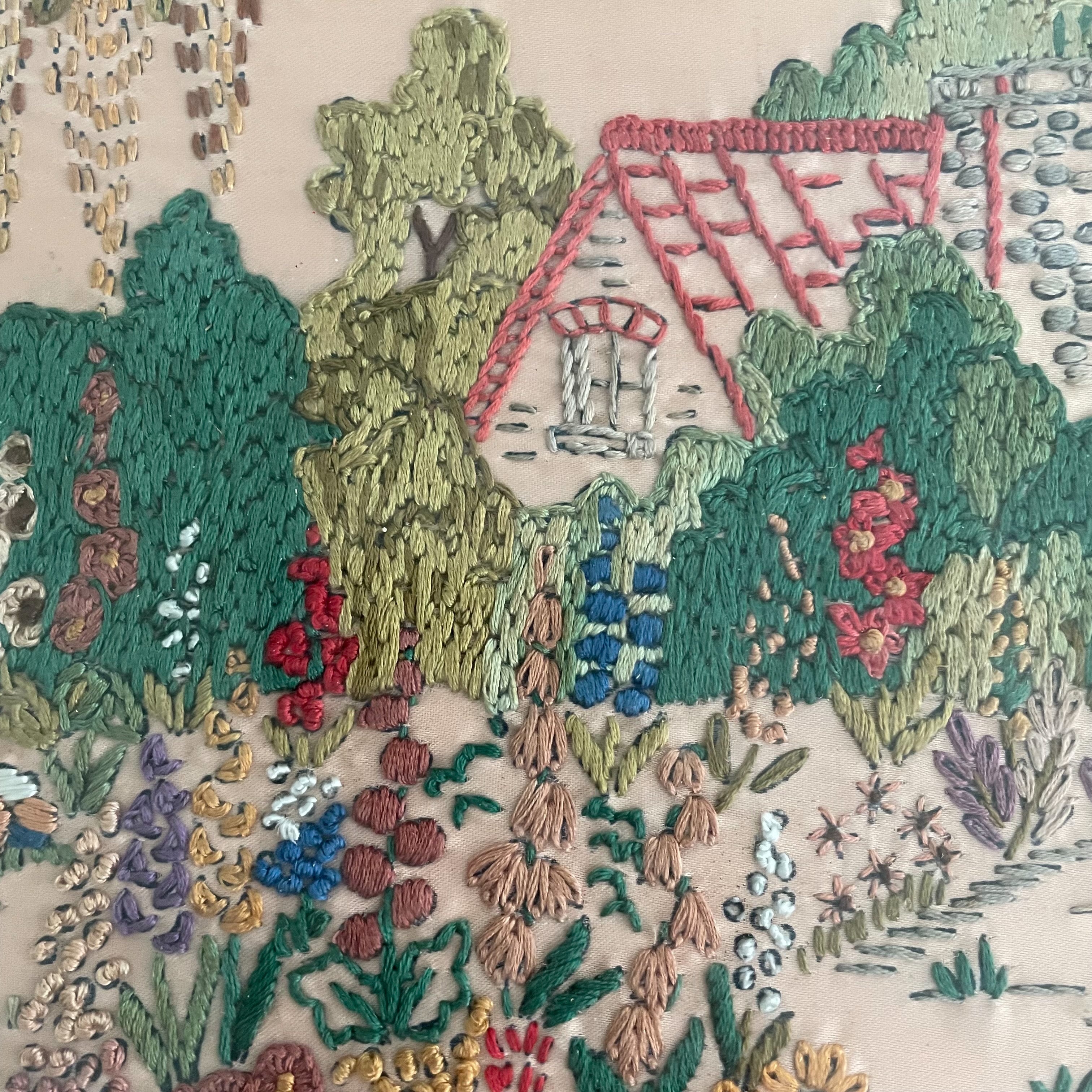 Vintage framed embroidery of a garden, house and bench, blush pink background - Moppet
